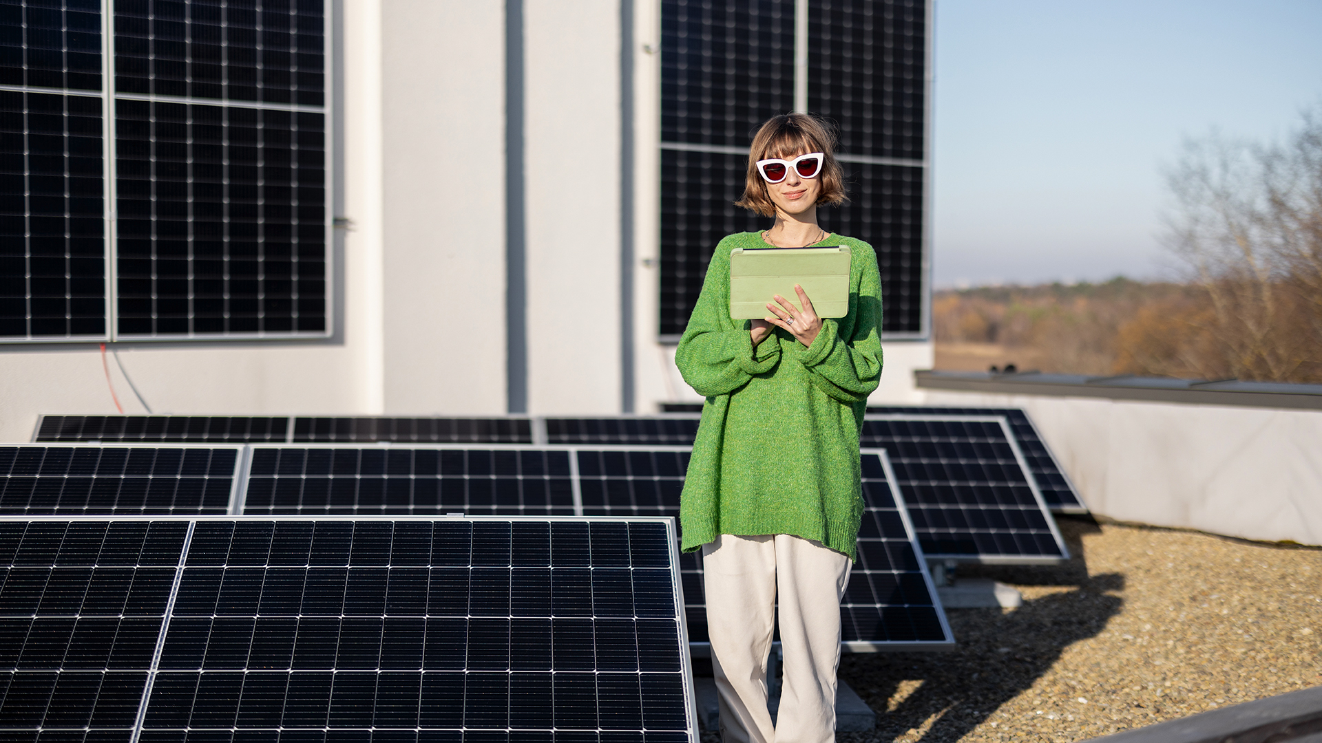 A woman standing in front of solar panels.
