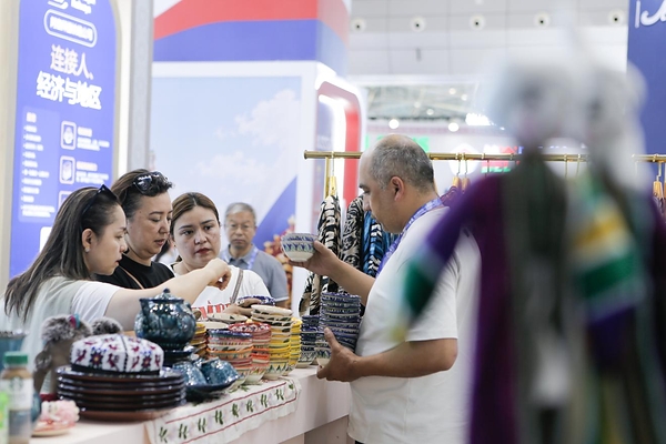 Visitors inspect products at the Uzbekistan booth on June 26. SHI FENG / XINHUA Visitors inspect products at the Uzbekistan booth on June 26. SHI FENG / XINHUA