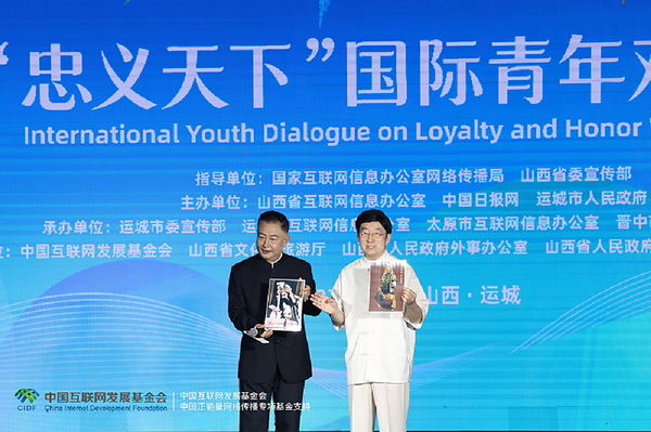 Li Zijun (right), a scholar of the Chinese Theatre Literature Society, displays a photo of